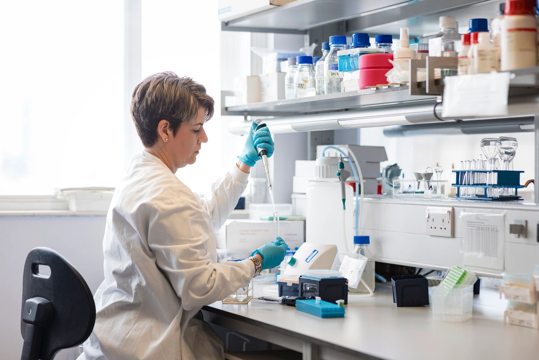 Lab professional working with test tubes in a quality control environment